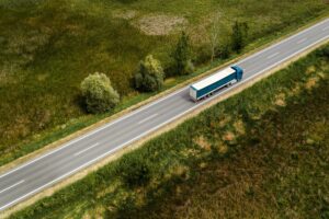 Large freight transporter semi-truck on the road, aerial view