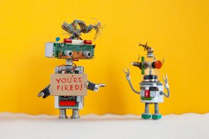 Robot chief dismisses younger robotic employer. Robotic character with a cardboard sign and