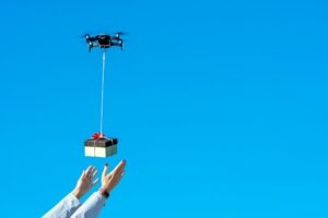 womans hands receiving the gift from flying drone